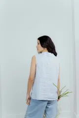 Chaleco celeste pastel con solapas y cierre con botones.