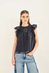Camisa blanca de algodón con escote redondo, mangas cortas con volados y detalles de puntilla en el canesú.