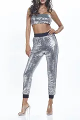 Conjunto plateado de lentejuelas, compuesto por un top bandeau y un pantalón tipo jogging con cintura y puños negros.