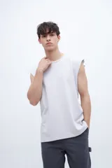 Musculosa gris con cuello redondo y estampado pequeño en el pecho. Corte clásico y sin mangas.