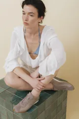 Zapatilla tipo runner color gris claro, de cuero y gamuza combinada, con suela de caucho blanca.