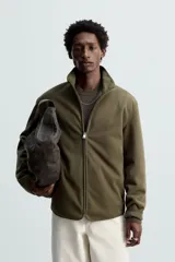 Sobrecamisa verde militar de tejido polar, corte regular fit, cuello alto, manga larga, bolsillos laterales y cierre frontal con cremallera.