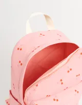 Mochila rosa con estampado de cerezas, correas regulables, manija superior, doble cierre superior y bolsillo frontal con cierre.
