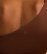 Blusa deportiva de microfibra color marrón, con escote asimétrico de un solo hombro y manga larga con recorte contrastante color beige.