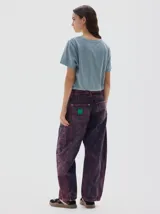 Jean sobreteñido, washed bordó, de pierna ancha que se estrecha hacia el tobillo, con cintura ajustada y corte relajado en cadera y muslo. Confeccionado en 100% algodón y con hilos color oro.