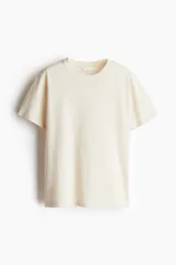Remera color crema de corte recto en punto suave de algodón con cuello redondo ribeteado y hombros ligeramente caídos.