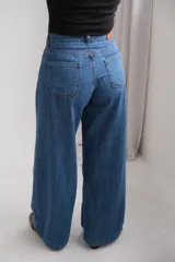 Jean de corte ancho y tiro medio, confeccionado en denim azul clásico. Presenta bolsillos traseros amplios y costuras en contraste.