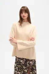 Sweater de viscosa color beige, con cuello polera, corte holgado y pespuntes decorativos en el frente.