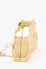 Bolso rígido con forma de media luna, color dorado, con efecto metalizado y cierre imantado. Incluye asa de cadena metálica extraíble para usar como bandolera.
