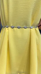 Cinturón plateado de metal con eslabones y apliques de strass con forma de ojo.