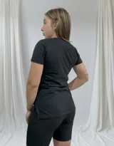 Remera negra de algodón con cuello redondo y estampado de cerezas y texto en rojo y blanco.