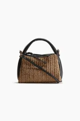 Cartera pequeña con cuerpo de paja trenzada color marrón claro y laterales de cuero sintético negro. Tiene asa corta de mano y correa larga extraíble para usar cruzada.