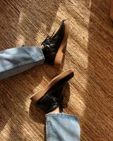 Zapato acordonado negro de cuero vacuno con suela track.