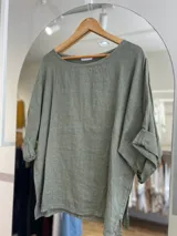 Blusa oversize color verde oliva, confeccionada en lino.
