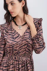 Vestido corto color marrón con estampado de cebra, escote en V, mangas largas con volados en los hombros y puños elásticos con volados.
