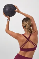 Top deportivo color verde militar con espalda cruzada en cuatro tiras y almohadillas removibles.