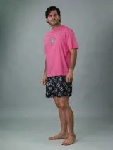 Conjunto de pijama Calvin Klein de dos piezas. Incluye una remera rosa de manga corta con cuello redondo y logo estampado en el pecho, y un short negro con estampado de corazones y logo de la marca.