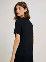 Remera color marrón claro, de corte recto, con cuello redondo y mangas cortas.