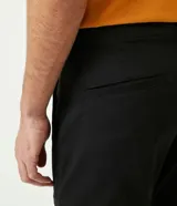 Pantalón de vestir color marrón, de corte slim y largo cropped. Confeccionado en tejido de algodón liso, con bolsillos laterales y traseros. Cierre frontal con botón y cremallera.