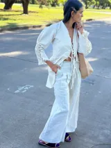 Camisa larga con punto smock y pollerín tipo blazer, con estampado floral en tonos beige y detalles de flecos rojos.
