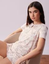 Conjunto de pijama marca René Rofé, compuesto por remera y short. Remera a rayas con escote redondo, ojal y botón. Short a rayas con cintura elastizada.