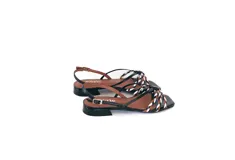 Sandalia de cuero negra con tiras finas y detalle frontal trenzado en colores blanco, marrón y negro. Pulsera ajustable con hebilla metálica y base plana con taco bajo geométrico.