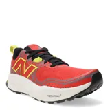 Zapatillas de trail running color rojo con detalles en negro y amarillo, diseño ligero y cómodo.