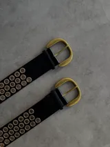 Cinturón negro de cuero ecológico con hebilla dorada y múltiples ojales dorados.