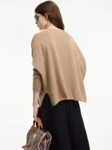 Sweater negro de hilo con textura brillosa, escote en v y manga larga.