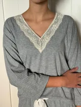 Pijama gris de algodón con puntilla blanca en escote en V, mangas largas y ruedo del pantalón.