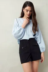 Short blanco de tiro alto con bolsillos delanteros con solapa y botones a la vista.
