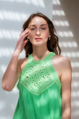 Vestido corto color violeta, con escote halter de crochet y falda escalonada.