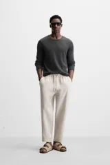 Pantalón de lino color marrón oscuro, de corte recto y relaxed fit. Tiene cintura elástica ajustable con cordón, bolsillos frontales y traseros de parche.