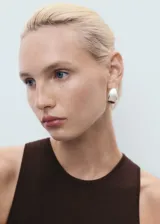 Vestido largo de punto color marrón oscuro, sin mangas, con cuello halter y diseño entallado.