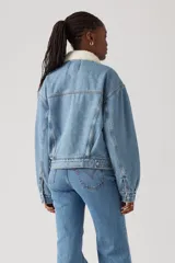 Campera de jean celeste con cuello de sherpa color crema, bolsillos frontales con solapa y cierre con botones metálicos.