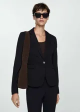 Blazer negro de corte entallado, con solapas de muesca, cierre de un botón, dos bolsillos de solapa y puños abotonados.