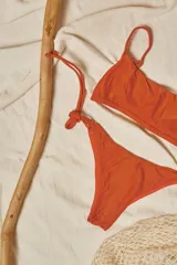 Conjunto de bikini con estampado animal print, compuesto por un corpiño bandeau con breteles finos y una bombacha vedetina con tiras laterales ajustables.