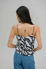 Blusa estampada con diseño abstracto en blanco y negro, de poliéster ligero y fluido, con escote drapeado y tirantes finos.