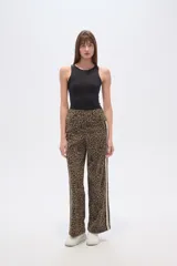 Pantalón ancho de tiro medio con estampado animal print de leopardo en tonos marrones y negros. Presenta una franja lateral deportiva en blanco y negro.