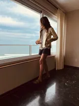 Campera de cuero ovino italiano color dorado, estilo motoquero, con cuello clásico, cierre frontal asimétrico y bolsillos con cierre.