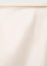 Falda midi color crema de tejido satinado, corte recto y cintura elástica.