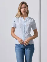 Blusa celeste de algodón con bordado broderie, cuello a la base con abertura central y botones.