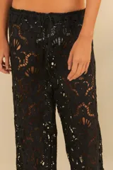Pantalón negro de corte amplio y fluido, con detalle de encaje floral.