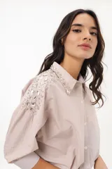 Camisa a rayas verticales color beige y blanco, con cuello clásico, manga larga abullonada y bordados de strass en hombros y cuello.