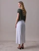 Pantalón crop de lino estampado con hojas en tonos verdes y azules. Tiene pretina trasera elastizada y bolsillos delanteros.