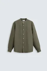 Camisa color beige claro de lino y algodón, corte relaxed fit, cuello mao, manga larga con puños abotonados y cierre frontal con botones. Marca Zara.