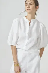 Camisa blanca de lino con cuello mao, mangas globo al codo y botones de nácar.