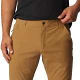 Pantalón de trekking color marrón claro, con protección solar UPF 50, repelente al agua y a las manchas. Cuenta con rodillas articuladas, puños cónicos, bolsillos con cremallera y detalles reflectantes.
