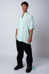 Camisa celeste de manga corta con cuello clásico y calce oversize.