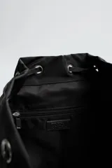 Mochila negra de tela técnica con compartimento principal con cierre de solapa y hebilla de liberación rápida. Tiene un bolsillo interior con cierre y un compartimento para dispositivos electrónicos de hasta 13 pulgadas. La parte frontal cuenta con dos bolsillos con cremallera. Tiene asa de mano y dos asas de hombro ajustables.